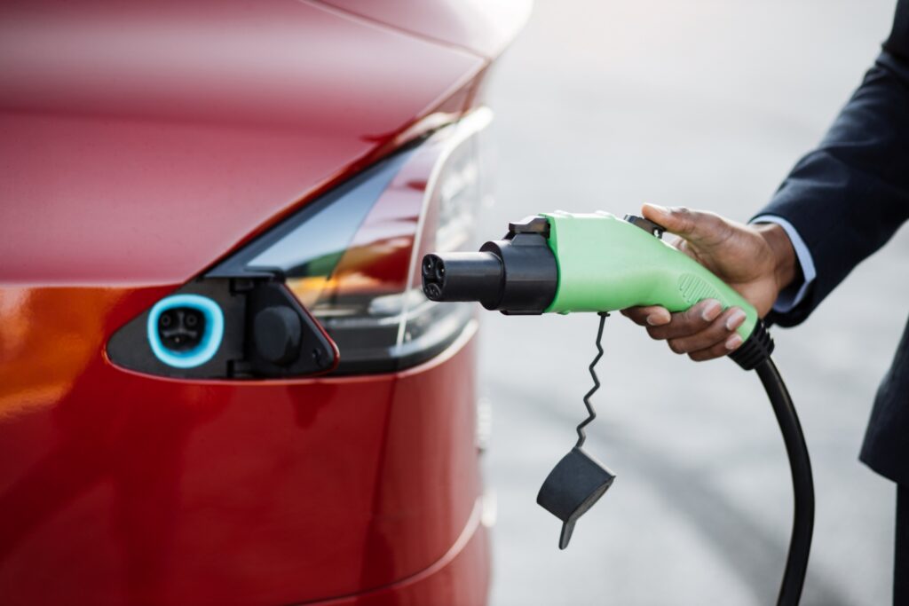 Persona cargando un coche eléctrico